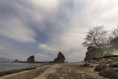 Rocks on beach against sky