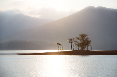 Scenic view of lake by mountains against sky