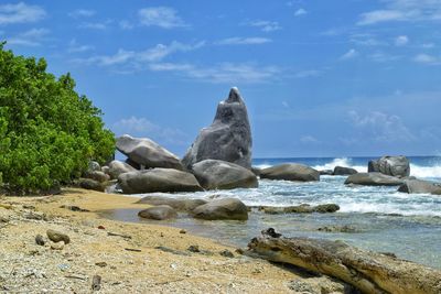 Rocks on beach against sky