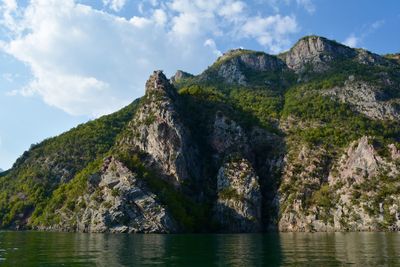 Scenic view of mountain by sea against sky