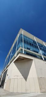 Low angle view of modern building against blue sky