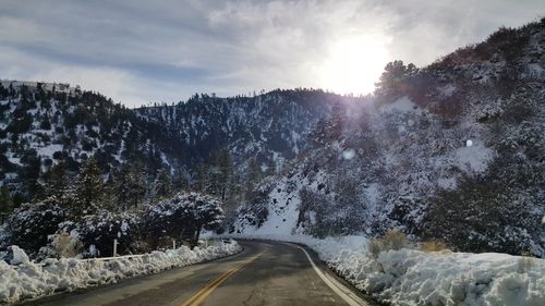 Road amidst trees against sky