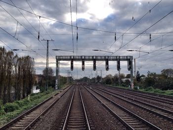 Railroad tracks against cloudy sky