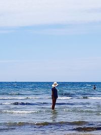 Man standing in sea against sky