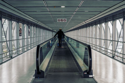 Rear view of man on moving walkway