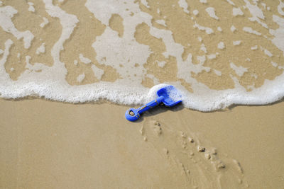 High angle view of toy shovel on shore at beach