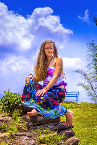 Portrait of young woman sitting on rocks