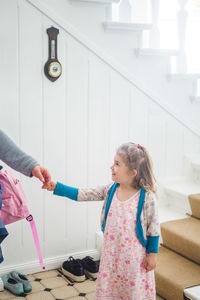 Smiling girl looking at father while leaving for school
