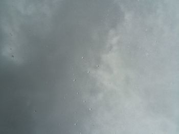 Low angle view of raindrops on sky