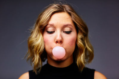 Portrait of beautiful woman against gray background