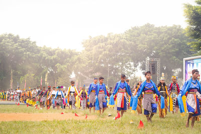 Group of people on field against trees