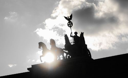Low angle view of silhouette statue against sky