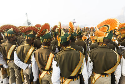 Rear view of marching band wearing uniforms on street