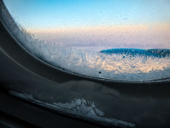 Close-up of wet airplane against sky