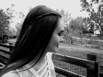 Young woman against trees