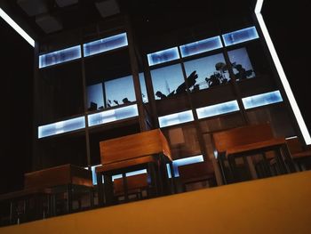 Man and chairs in illuminated room