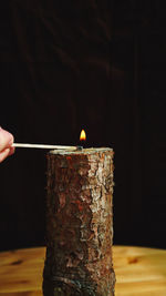 Close-up of hand holding burning matchstick