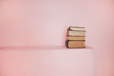 Close-up of books on table against wall