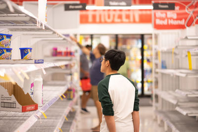 Rear view of man standing at store