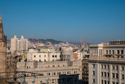 Buildings in city against blue sky