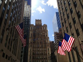 Low angle view of flags against buildings in city