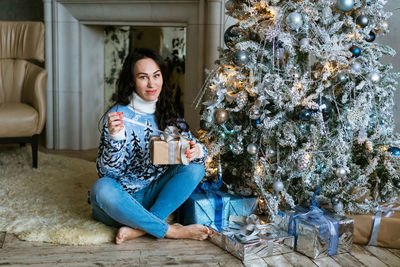 Portrait of young woman sitting on sofa at home