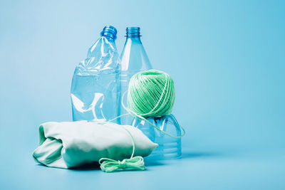 Green bottle against blue glass on table