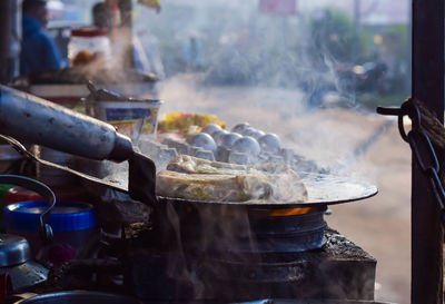 Making of egg bread roll on a hot frying pan with oil, digha beach, west bengal.