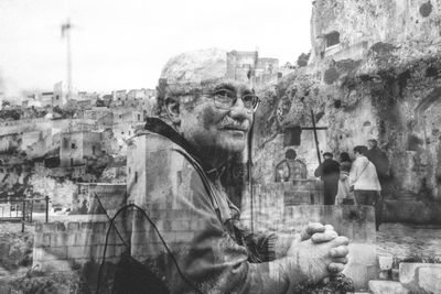 Portrait of man standing by buildings in city