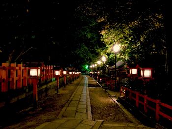 Illuminated railroad tracks in city at night