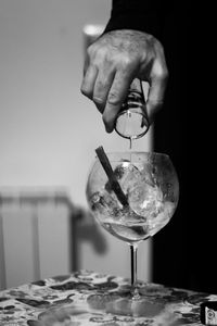 Close-up of hand pouring wine in glass on table