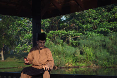 Man sitting by plants in forest