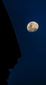 Low angle view of moon against blue sky at night