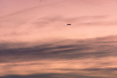 Low angle view of silhouette airplane against sky during sunset