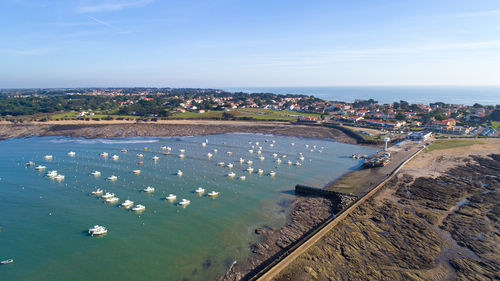 High angle view of sea by cityscape against sky