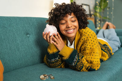 Portrait of young woman sitting on sofa at home