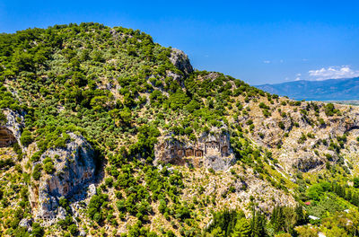 High angle view of trees and mountains against blue sky