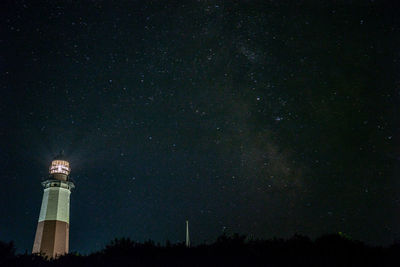 Low angle view of lighthouse against sky at night