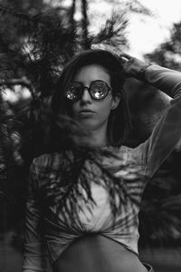 Portrait of woman with sunglasses against trees