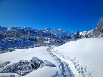 Scenic view of snowcapped mountains against clear blue sky