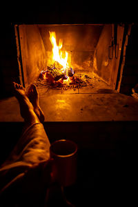 Low section of person by fireplace at home