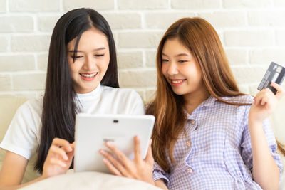 Portrait of a smiling young woman using mobile phone