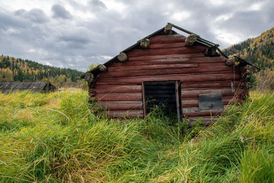 Abandoned house on field against sky