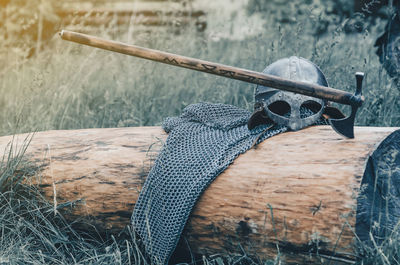 Metal chain mail, helmet and ax lie on wooden log. viking armor. historical film concept.