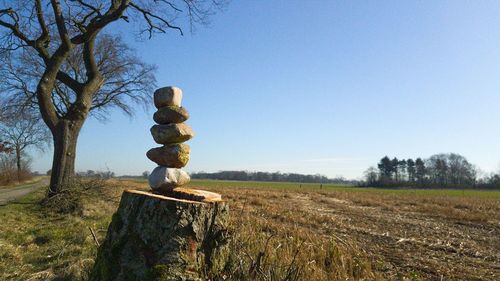 Stone wall on field against clear sky