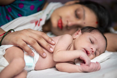 High angle view of mother and daughter on bed at home
