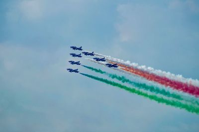 Low angle view of airshow against sky