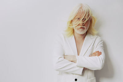 Portrait of woman standing against white background