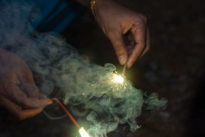 Close-up of hand holding lit candle