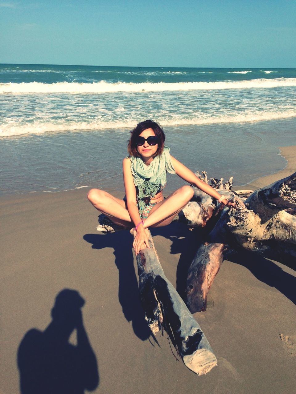 beach, sea, person, young adult, sand, portrait, lifestyles, shore, looking at camera, leisure activity, water, horizon over water, young women, sunglasses, front view, smiling, sitting, casual clothing